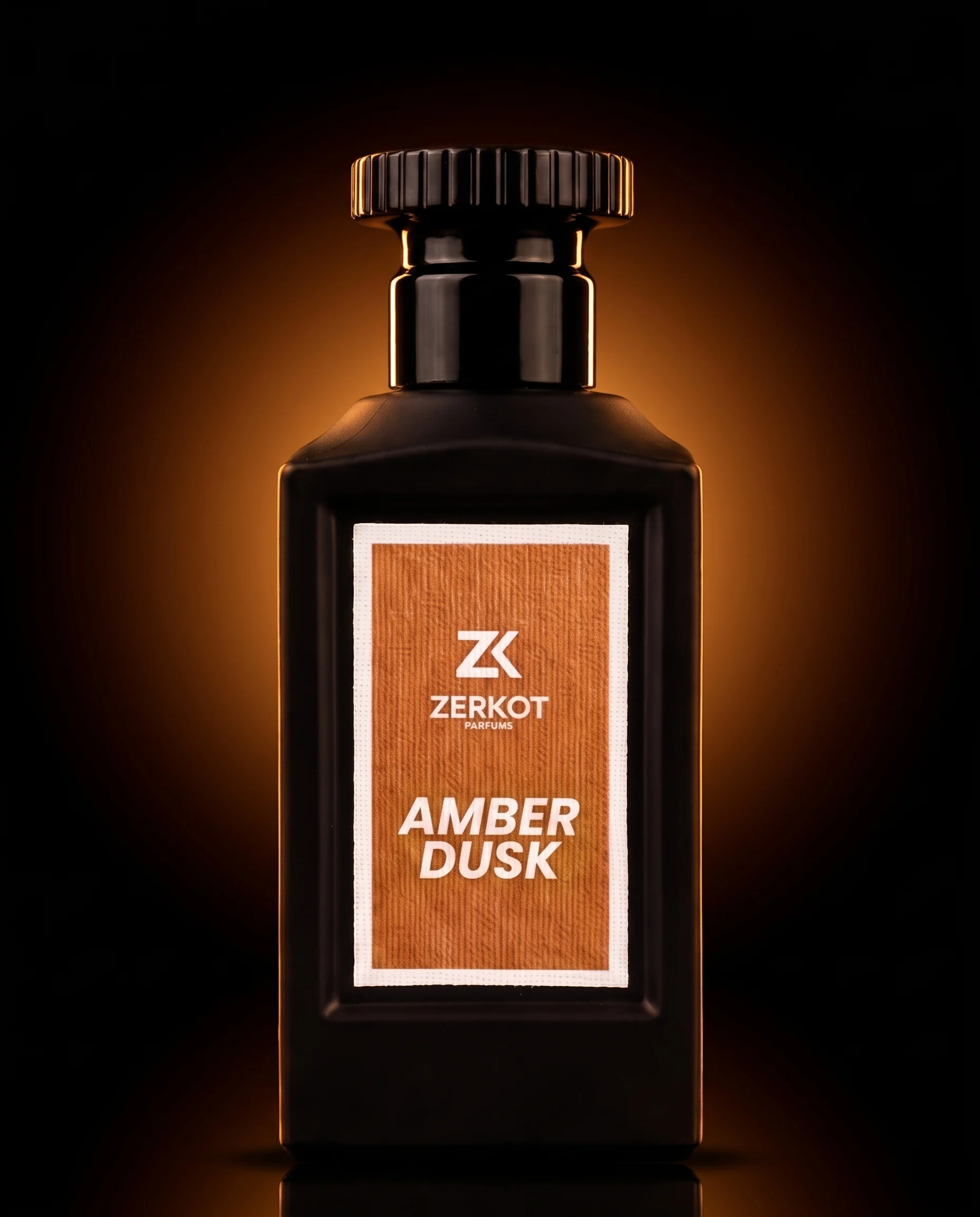 ZERKOT PARFUMS Amber Dusk — mattschwarzer Flakon auf dunklem Marmor, warmes Studio-Licht und Reflexion